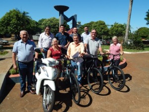 #PraCegoVer #PraTodosVerem – Imagem dos ganhadores dos prêmios com integrantes do governo e as bicicletas e moto.